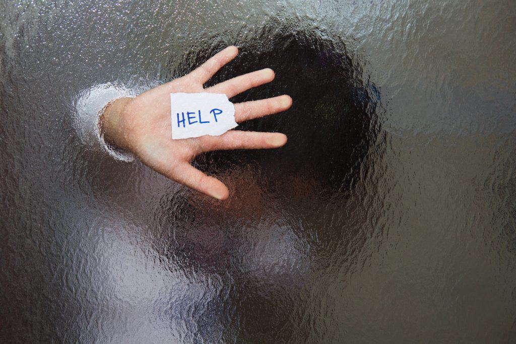 person blurred behind wavy glass pressing help sign up to the glass